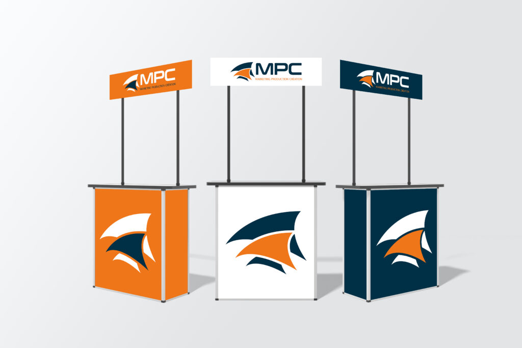 Trois comptoirs publicitaires d'accueil pour stand d'exposition, présentés en trois déclinaisons de couleurs (orange, blanc et bleu marine) avec le logo de l'entreprise "MPC Marketing Production Création".