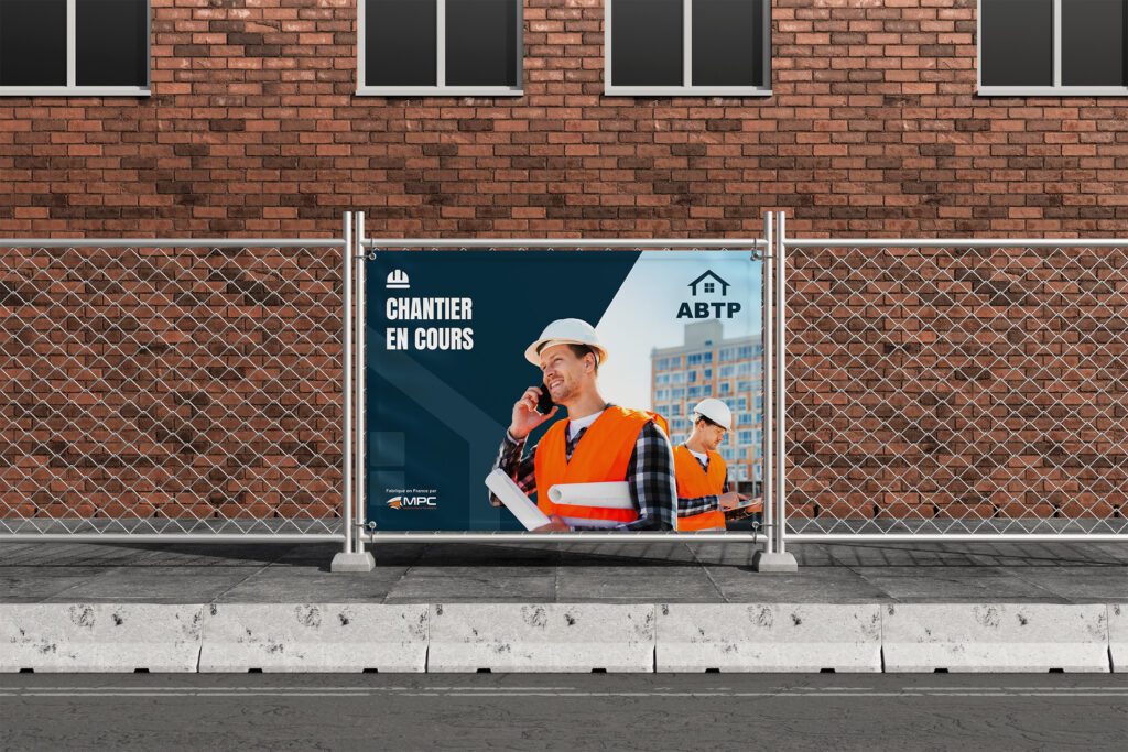 Bâche publicitaire de chantier "Chantier en cours" pour l'entreprise ABTP, fixée par œillets sur une barrière Heras le long d'une rue, fabriquée par MPC.