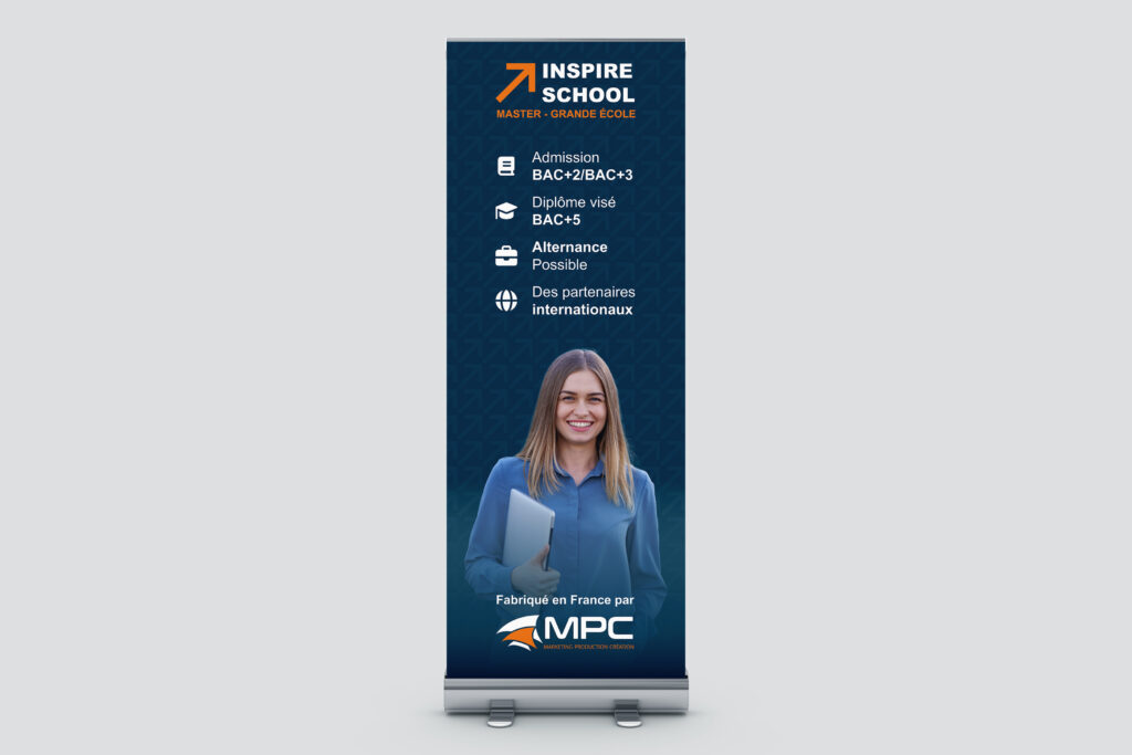 Kakemono roll-up publicitaire vertical pour l'école "Inspire School", affichant les conditions d'admission, la photo d'une étudiante avec une tablette et le logo MPC, sur un fond gris neutre.