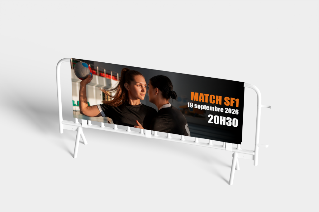 Bâche publicitaire fixée sur barrière de sécurité blanche, annonçant 'Match SF1 - 19 septembre 2026 - 20h30' avec photo de deux joueuses de handball.